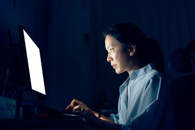 Side view of woman typing on keyboard computer 