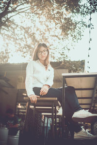 Young woman using mobile phone while sitting on seat