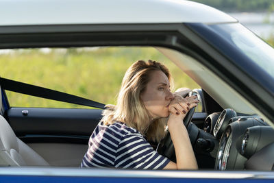 Side view of depressed woman sitting in car