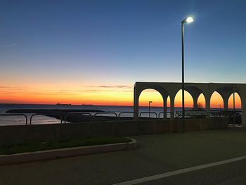 Bridge over sea against sky during sunset