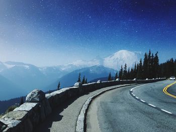 Road amidst snowcapped mountains against sky