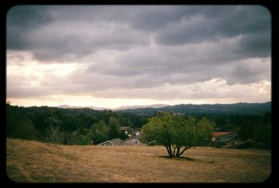 Scenic view of field against cloudy sky