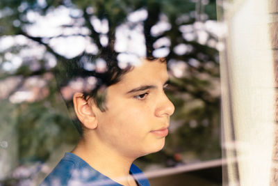 Teenage boy looking through window