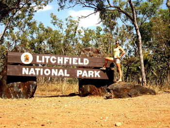 Woman standing by sign board with litchfield national park text