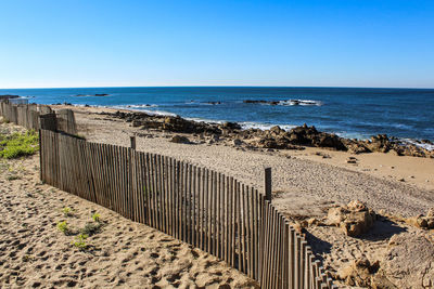 Scenic view of beach against clear blue sky