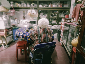 Rear view of woman sitting on chair