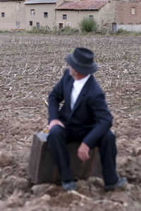 Portrait of man sitting on rock