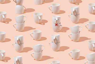 Creative pattern of cups on pastel pink background. minimal concept. isometric layout