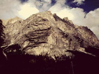 Low angle view of mountain against cloudy sky