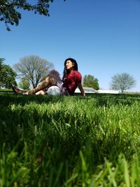 Full length of young woman on field against clear sky