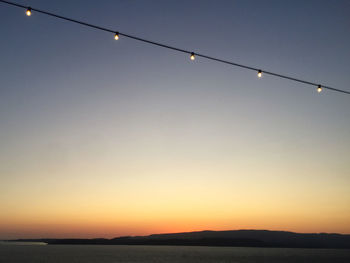 Low angle view of illuminated light against clear sky at sunset