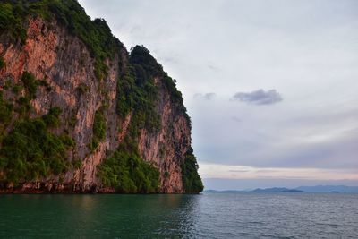 Rock formations by sea against sky