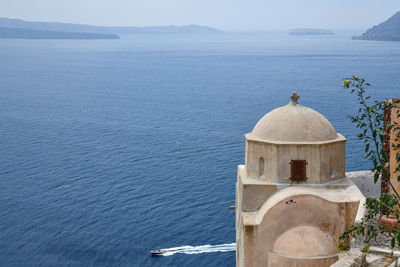 Traditional building by sea against sky