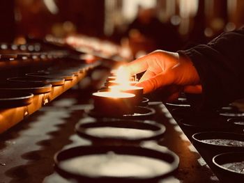 Person holding lit tea light candles in church