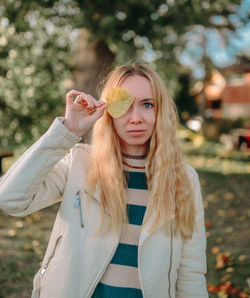 Portrait of smiling young woman looking away while standing outdoors