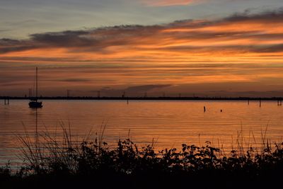 Scenic view of lake against orange sky