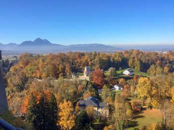 Trees and townscape against sky during autumn
