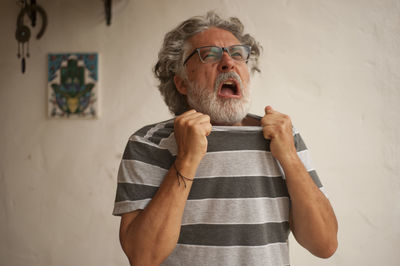 Portrait of man wearing mask standing against wall