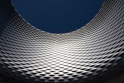 Low angle view of modern building against blue sky