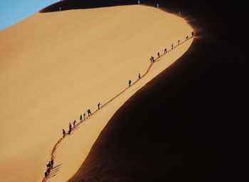 People walking on sand dune
