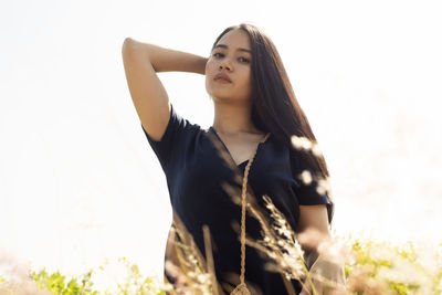 Portrait of woman standing against sky