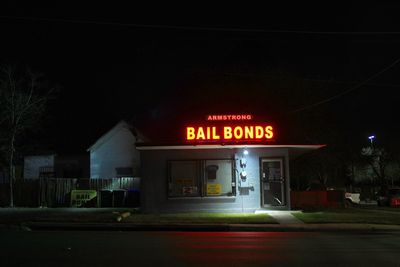 Illuminated sign on street in city at night