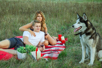 Portrait of smiling young woman with dog on grass