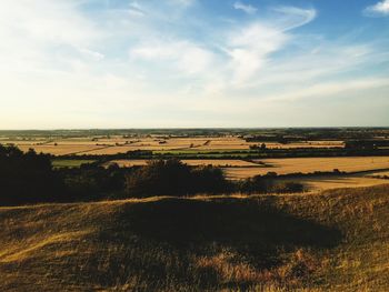 Scenic view of field against cloudy sky