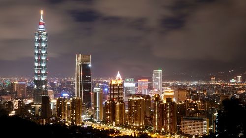 Illuminated buildings against sky at night