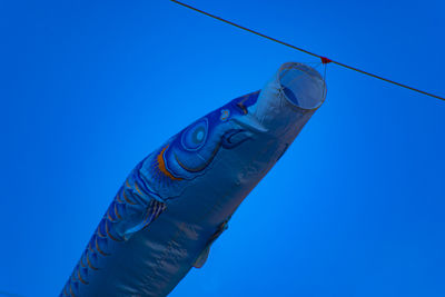 Low angle view of water bottle against clear blue sky