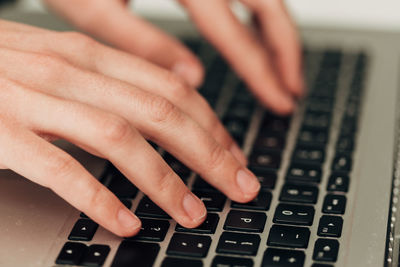 Cropped hands typing on keyboard