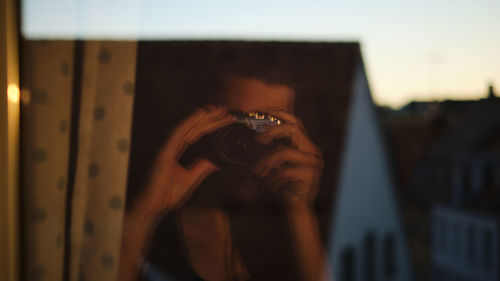 Portrait of woman photographing through camera