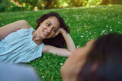 Portrait of a smiling young woman lying on grass