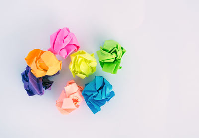 Close-up of multi colored paper over white background