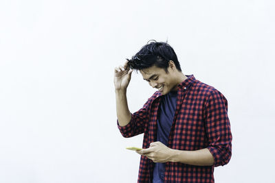 Young man looking away against white background