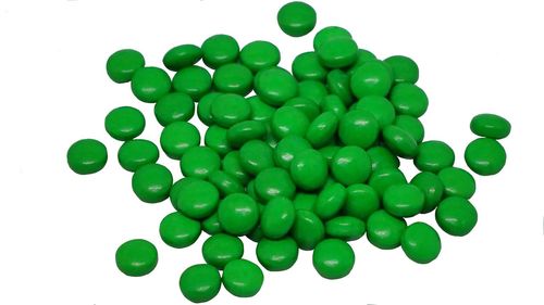 Green candies against white background