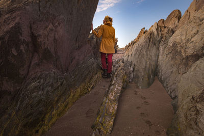 Rear view of man walking on rock