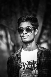 Portrait of young man wearing sunglasses standing outdoors