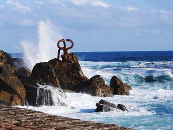 Scenic view of rocks in sea against sky