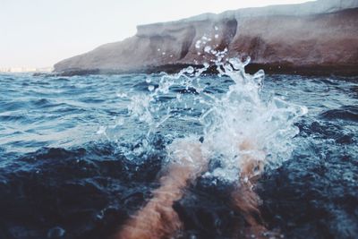 Close-up of waves splashing on sea against sky