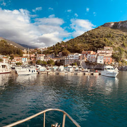 Scenic view of sea by town against sky