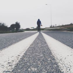 Rear view of man walking on road