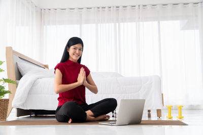 Full length of woman sitting on mobile phone