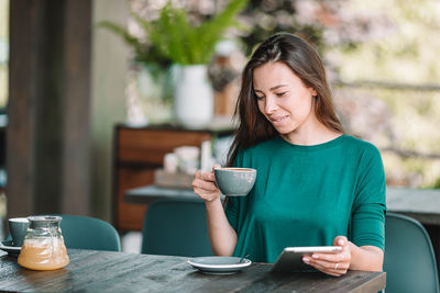 Woman sitting on table at restaurant