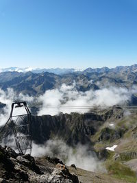 Scenic view of mountains and cable car against clear sky