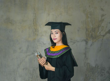 Portrait of beautiful woman standing against wall