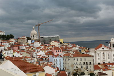 Buildings in city against cloudy sky