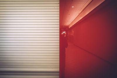 Reflection of person on red wall in shopping mall