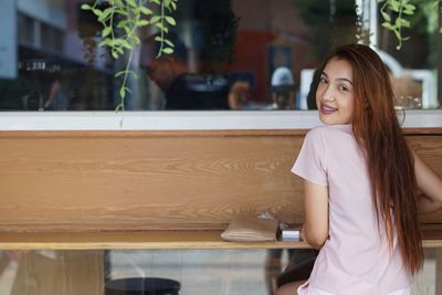 Portrait of young woman sitting at table in cafe