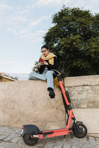 Teenager texting over smart phone sitting on wall